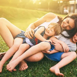 Mother playing with her children on the lawn.