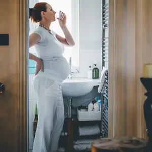 A pregnant woman drinking water.