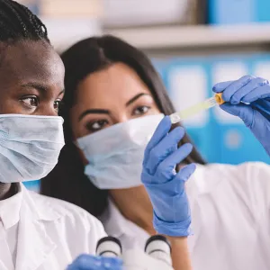 Two scientist looking at a vile in the lab