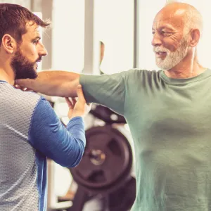 Trainer helping a person perform exercises