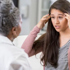 A woman discusses her symptoms with her doctor.