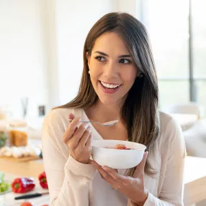 A Young Woman Snacks on Some Yogurt