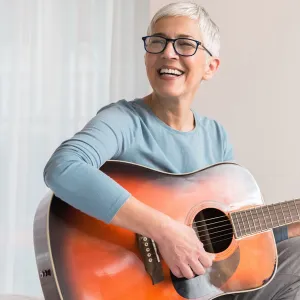 A woman strumming a guitar. 