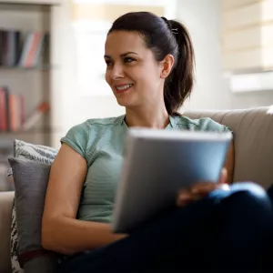 A woman reading on her couch at home.