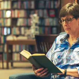 Woman reading book in library