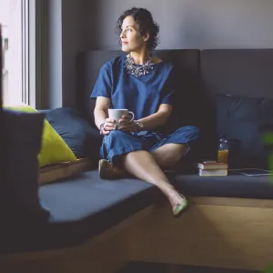 Woman on a couch with coffee.