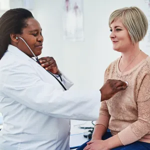 An adult woman gets her heart checked at the doctor office