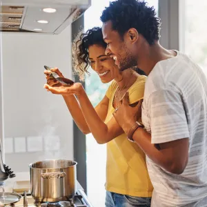 A young couple cooking in their kitchen at home.