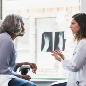 A patient and physician looking at foot x-rays