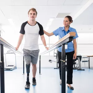 Man with prosthetic leg working with rehab professional