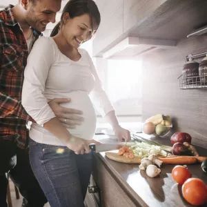 A pregnant woman prepares a healthy meal.