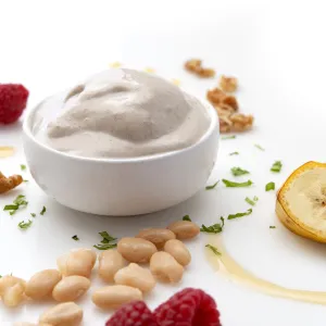 a bowl of homemade vanilla ice cream, surrounded by banana slices, walnut pieces, cannellini beans and raspberries