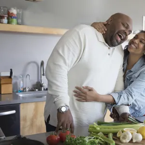 A mature couple enjoying their time while cooking.