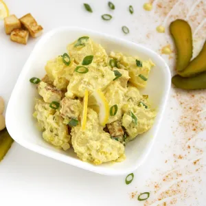 Bowl of potato salad with pickle garnish