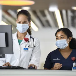 Two female physicians looking at a computer