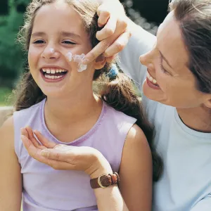 Mom applying sunscreen to daughter