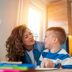 A child laughing as he looks at her smiling mother. 