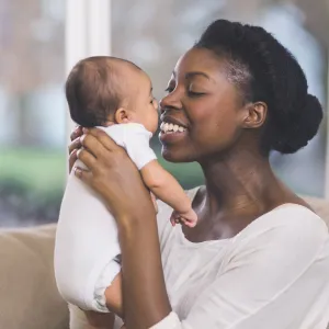 Mother holding her baby and smiling.