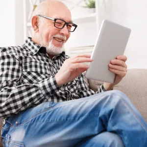 Older man reading on electronic device