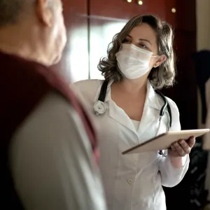 An older man talking to his doctor. 