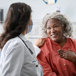 An older black woman talking with her doctor.