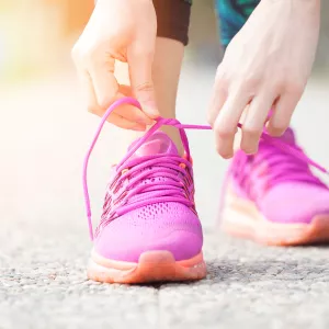 A female runner tying her pink running shoes