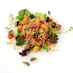 a large scoop of cooked quinoa, mixed with colorful squash and peppers