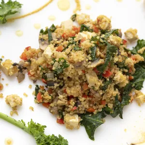 Mound of scrambled tofu with kale garnish on white counter