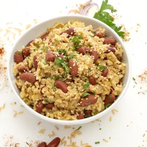 Bowl of beans and rice with grain sprinkled decoratively by bowl