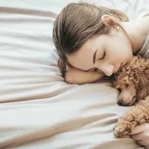 A woman gets some rest with her puppy.