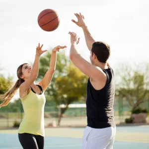 man and woman playing basketball