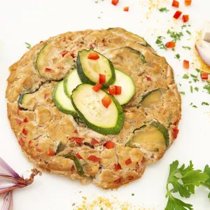 a flat, plant-based frittata, with zucchini and red bell peppers