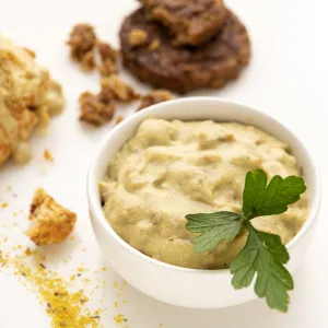 Bowl of gravy, chicken cutlet topped with gravy, and two chocolate cookies