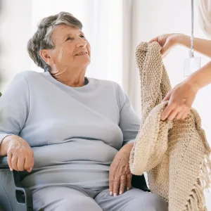 Ederly woman taking blanket from nurse