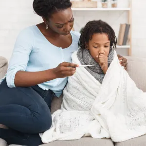 A mother taking her sick child's temperature 