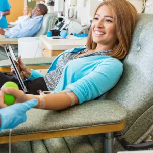 Smiling woman donates blood