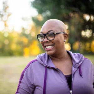 A woman smiles while at a park.