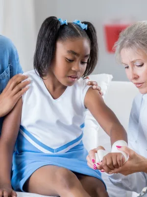 Doctor checking the arm of a young cheerleader.