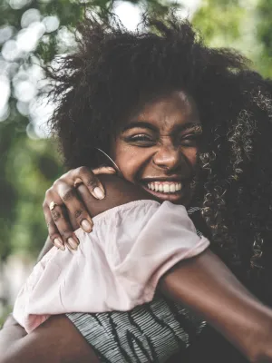 Two women hugging and smiling.