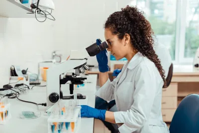 A woman researcher using a microscope.