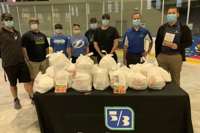A group of people standing at a table with food donations