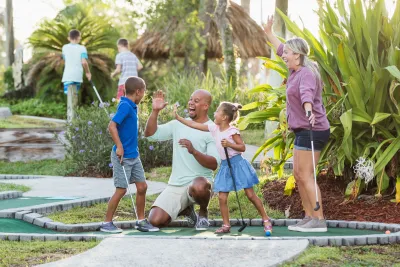 A Family Congratulates Their Son For Winning at Putt Putt Golf.