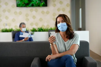 Woman using her phone while in the AdventHealth Partin Settlement Health Park lobby.