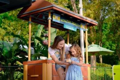 A Mother and Daughter Stop for a Healthy Snack at the EPCOT Flower and Garden Festival Butterfly Landing