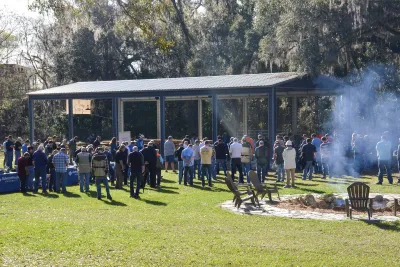 AHU Clay Shoot group have their heads bowed for prayer