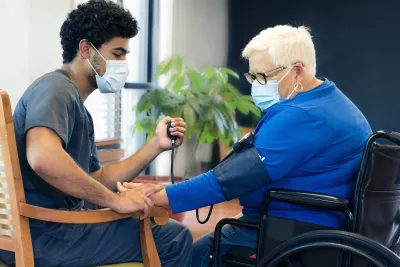 A health care professional checks a woman's blood pressure.