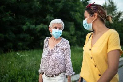 Two ladies talking while wearing masks