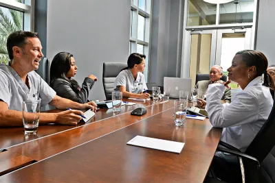 People having a meeting in the Nicholson Center Executive Boardroom.