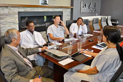 People having a meeting in the Nicholson Center Executive Boardroom.