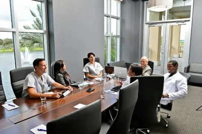 People having a meeting in the Nicholson Center Executive Boardroom.